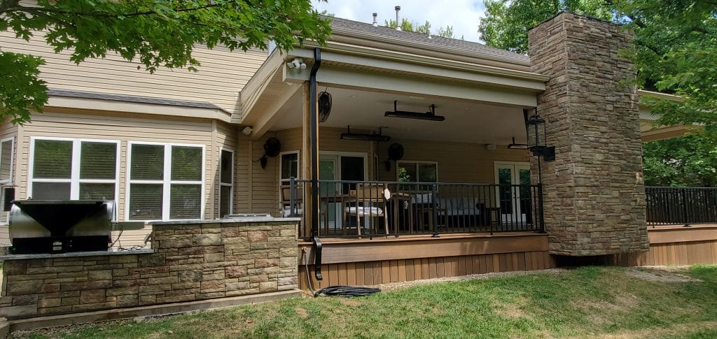 An outdoor kitchen and backyard patio attached to a home in Des Peres, MO