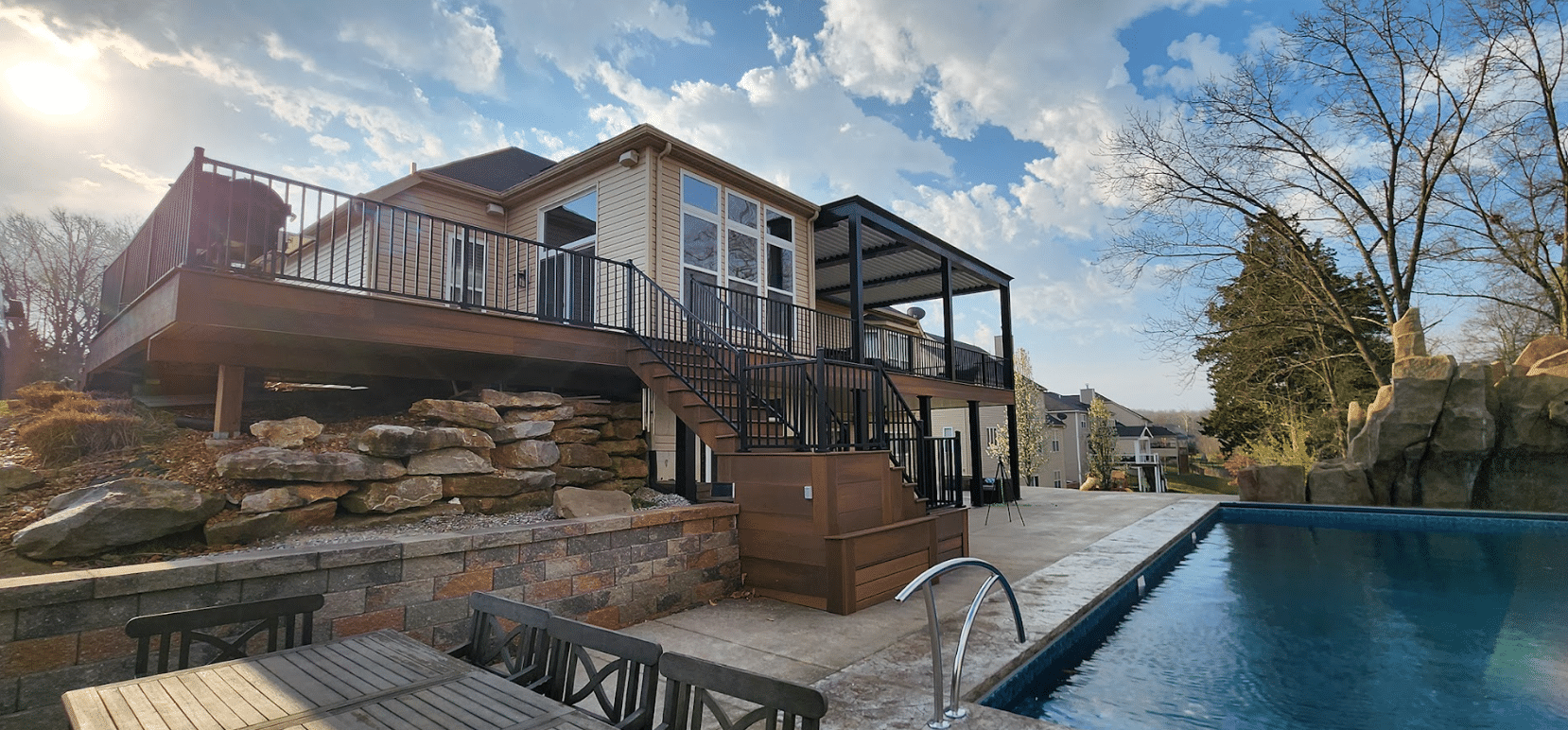 custom deck with sunroom, louvered roof pergola, and underdeck patio area